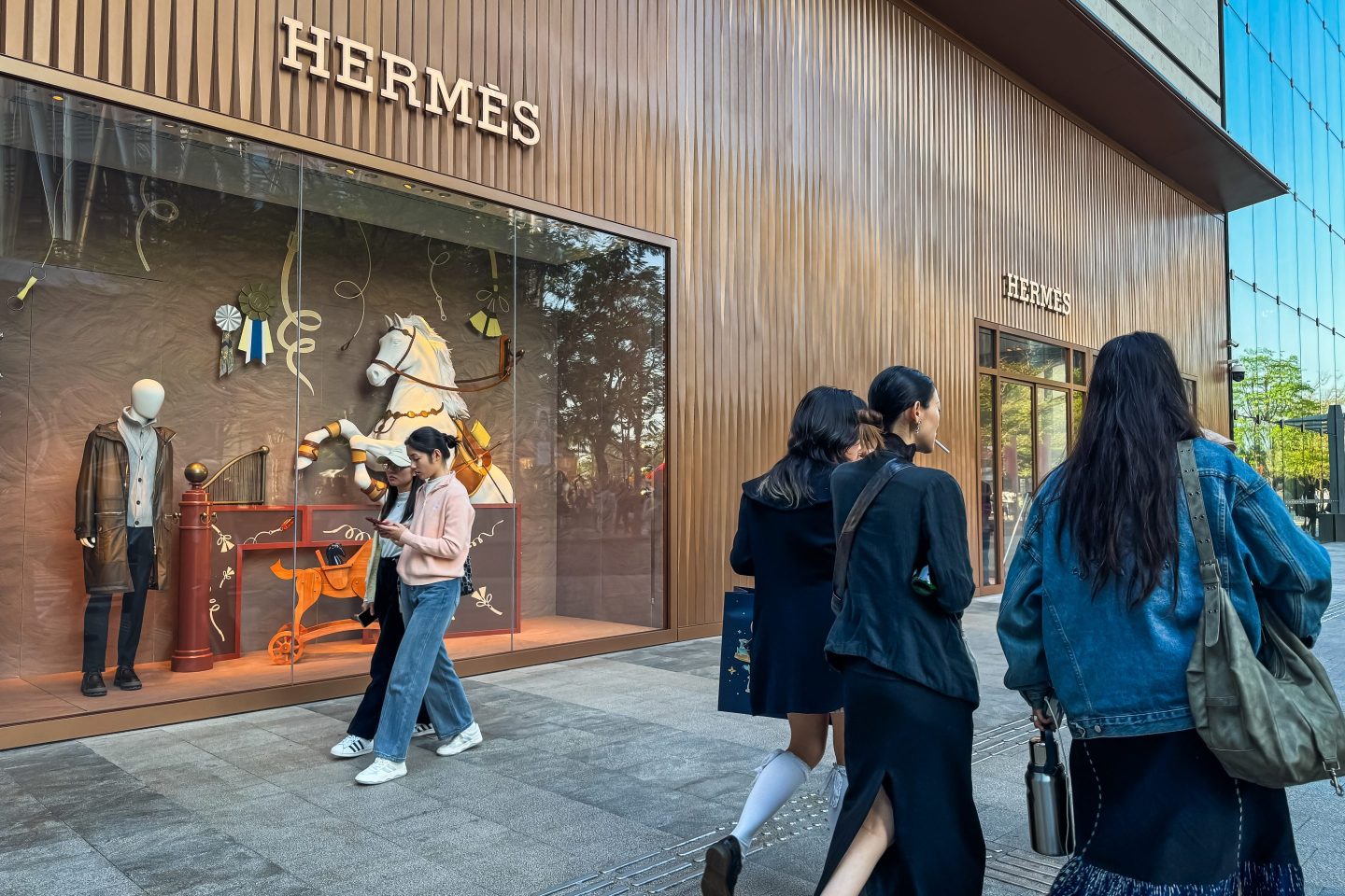 people walking outside hermes store