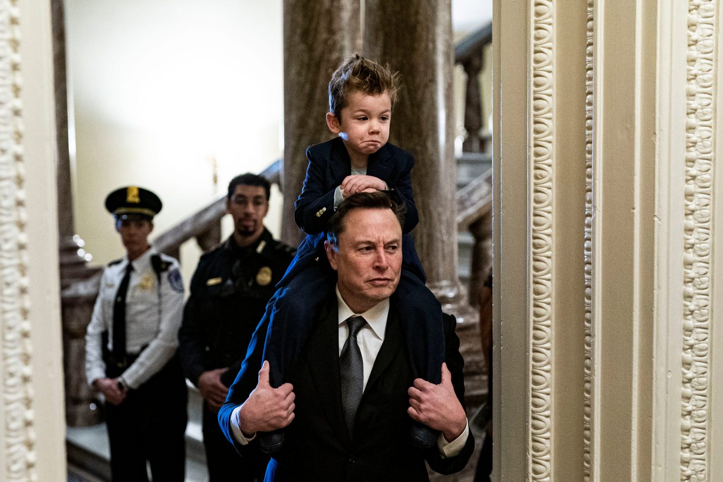 Elon Musk with one of his children on his shoulders