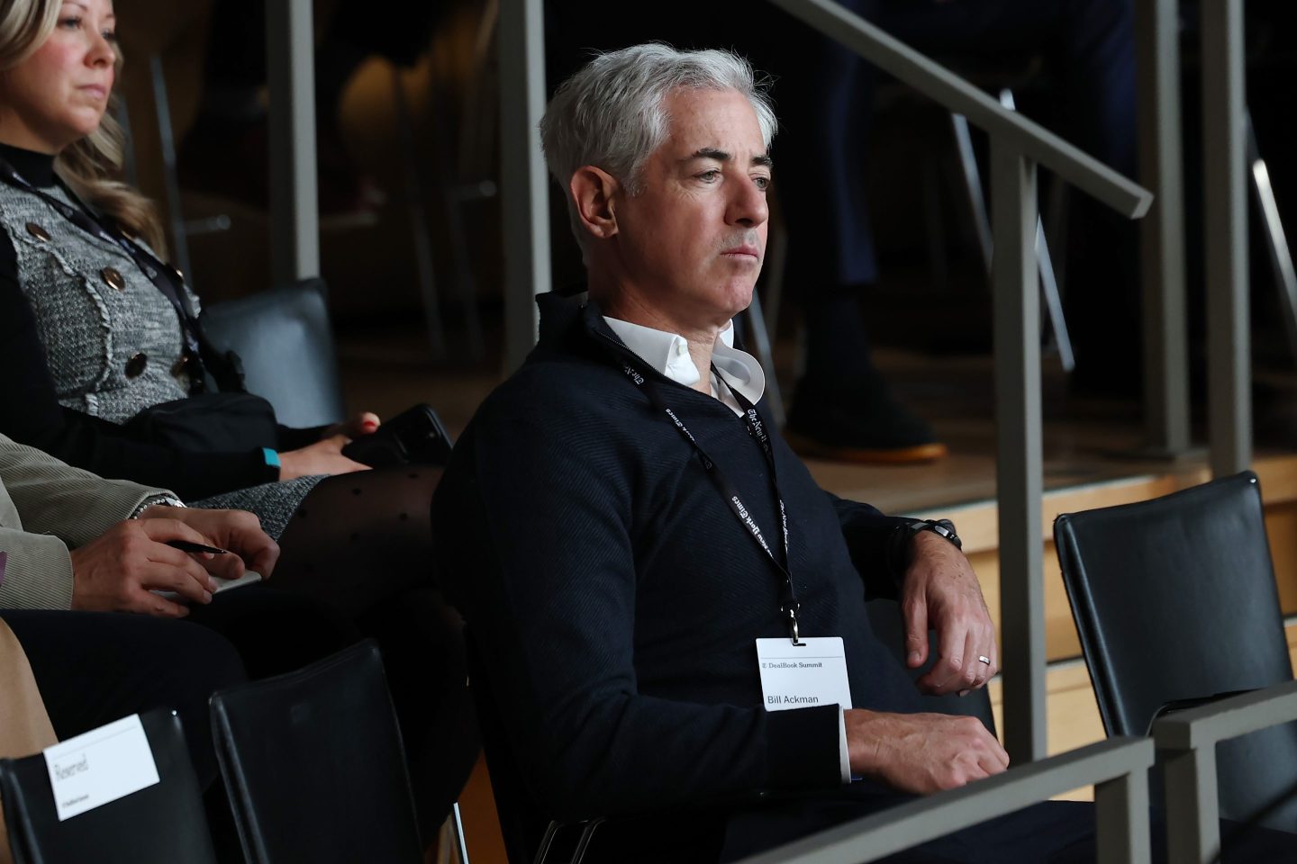 Bill Ackman sits and looks on pensively.