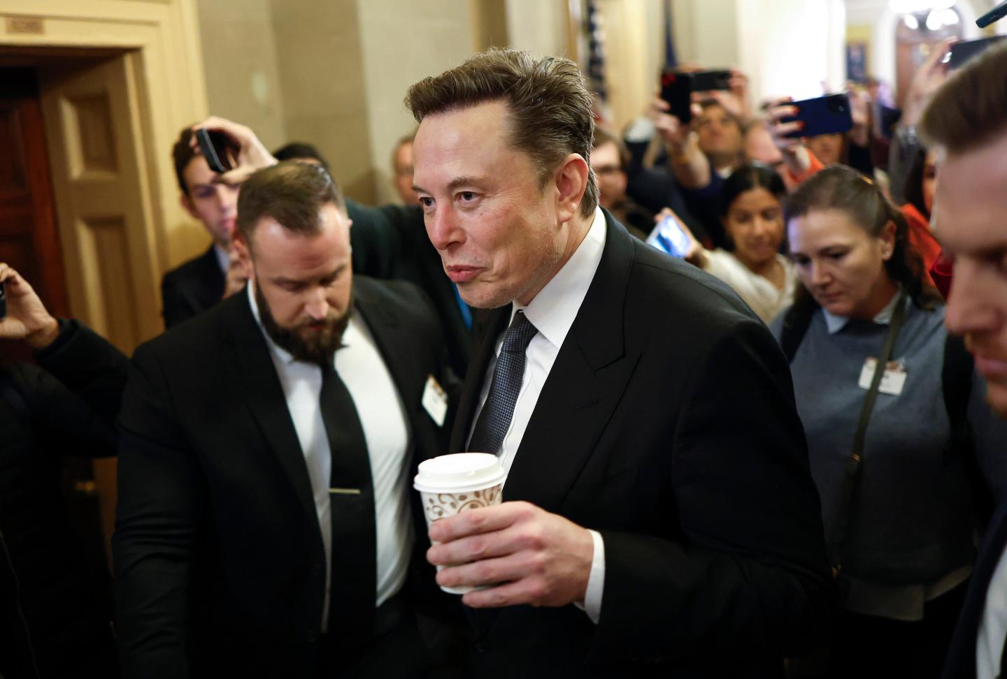 Elon Musk walking through a crowd in capital hill.