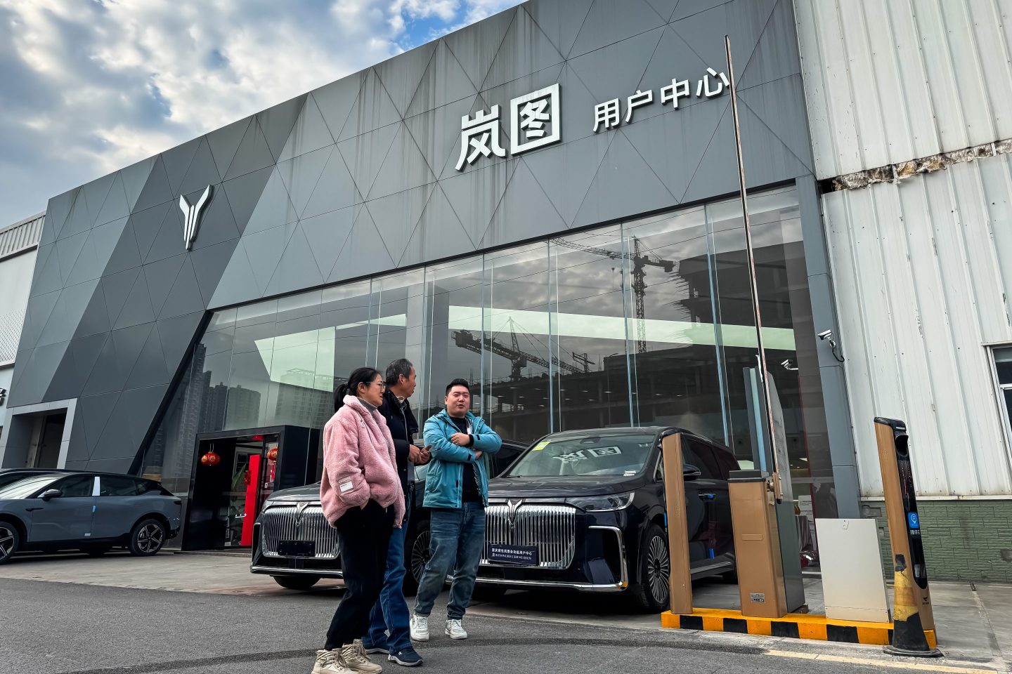 A showroom of Voyah, the high-end electric vehicle brand under Dongfeng Motor Corporation, featuring its logo and flagship EV model, is seen as pedestrians walk past on Jan. 12, 2025, in Chongqing, China. 