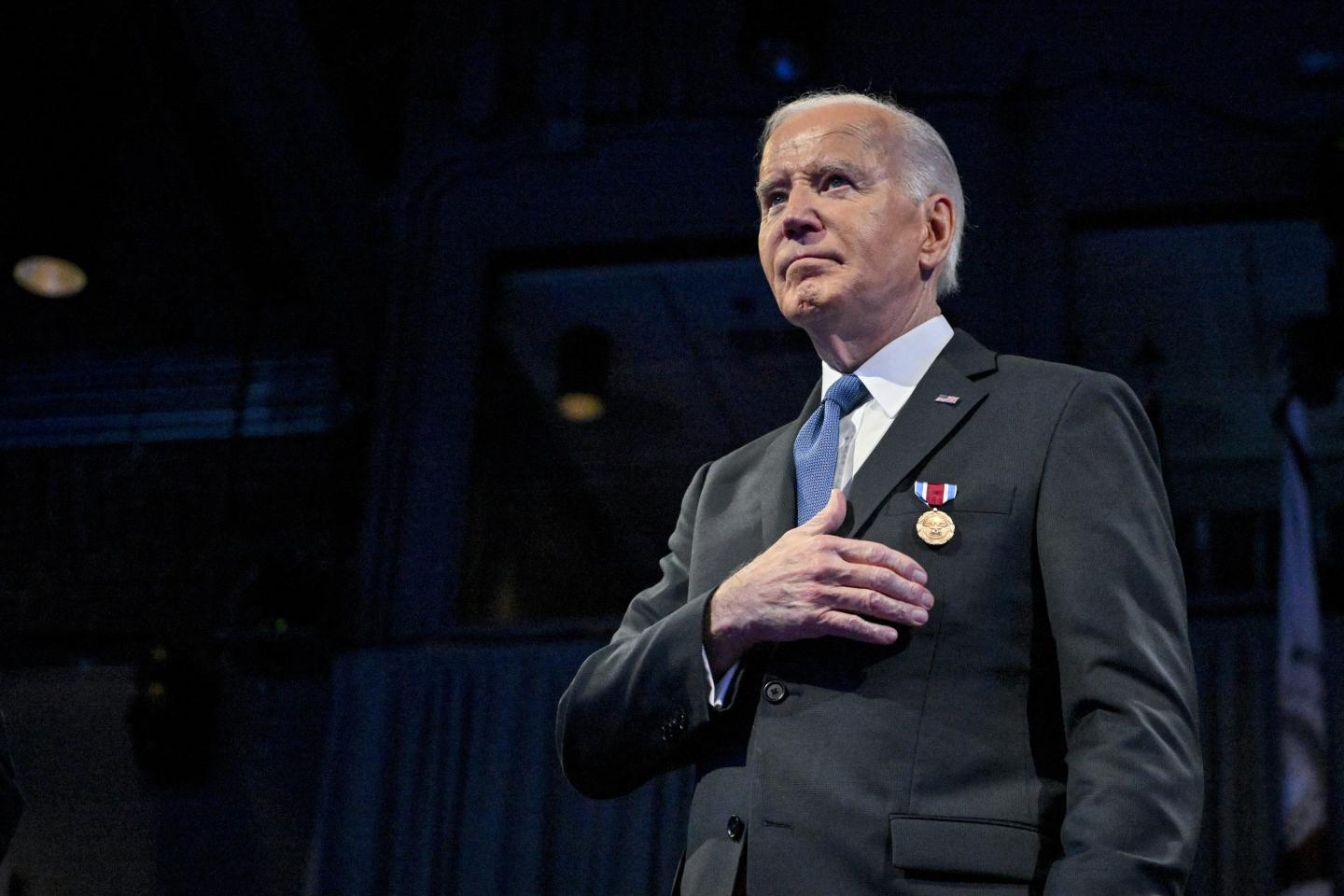 Joe Biden standing with a medal