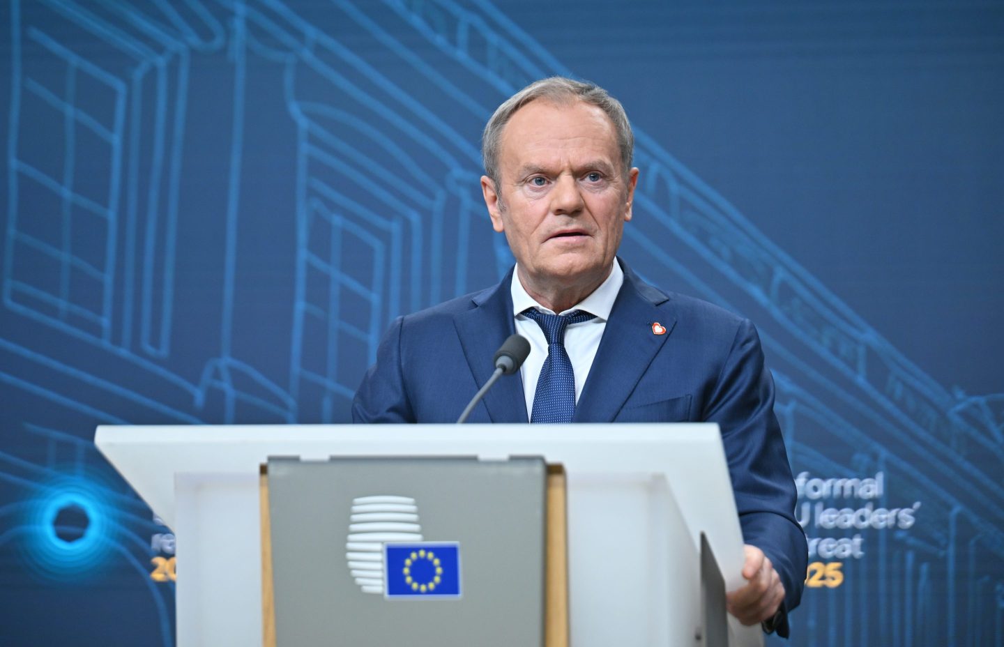 Donald Tusk stands at a podium