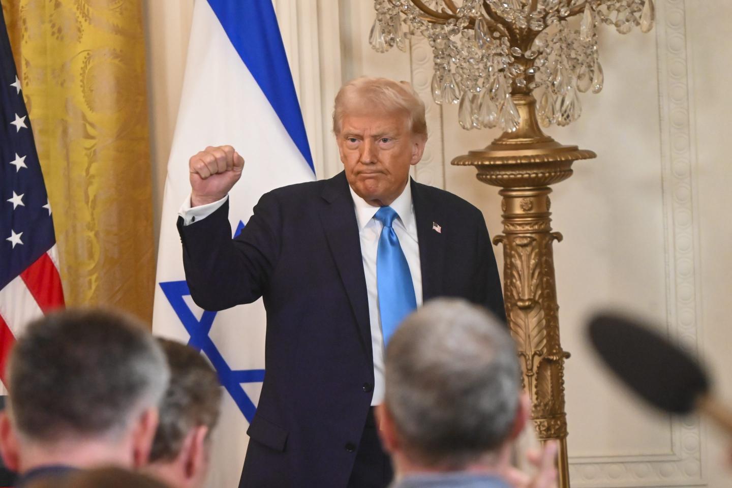 Trump pumps his fist at a press conference welcoming Israeli Prime Minister Benjamin Netanyahu