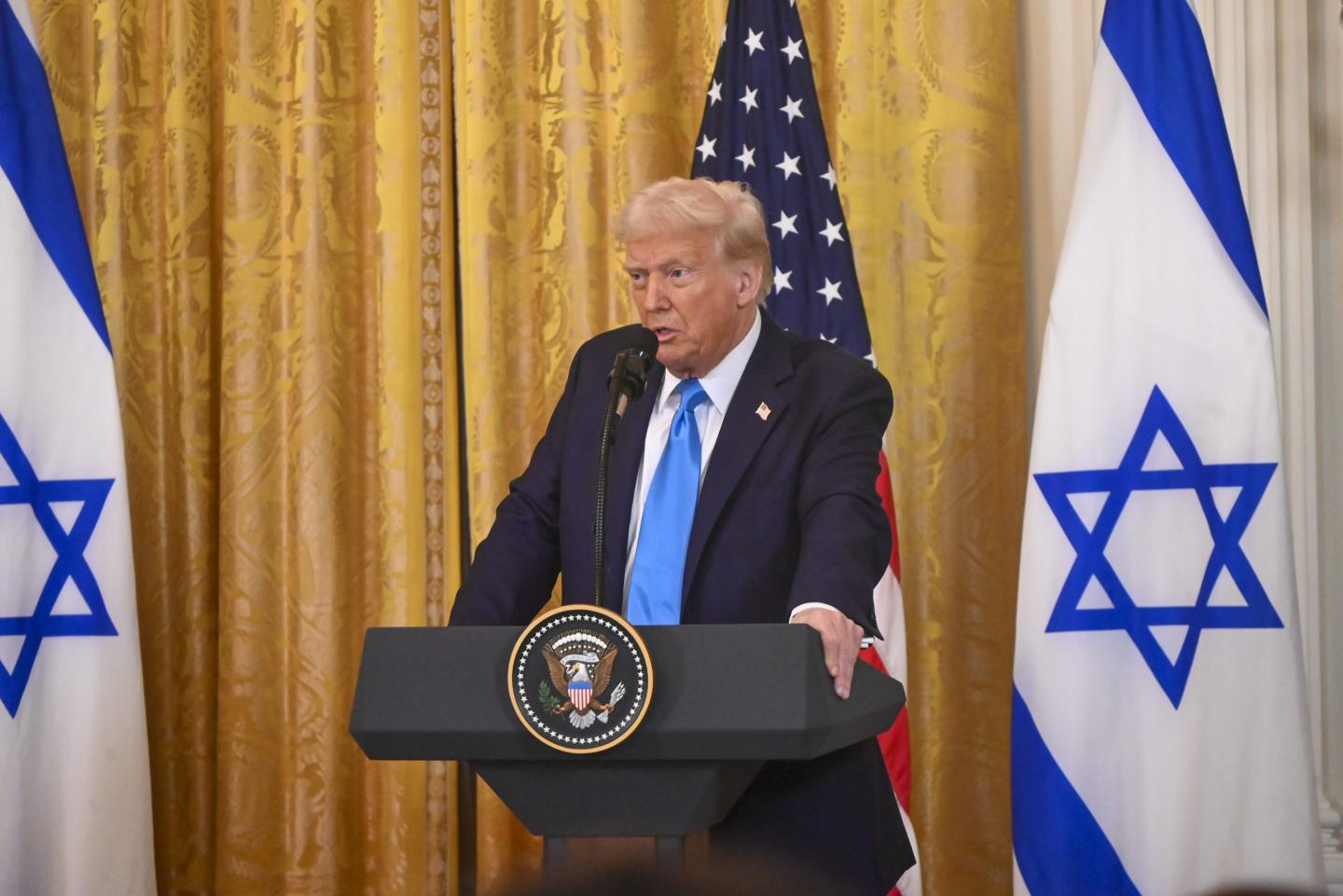 Trump speaks in front of the American and Israeli flags
