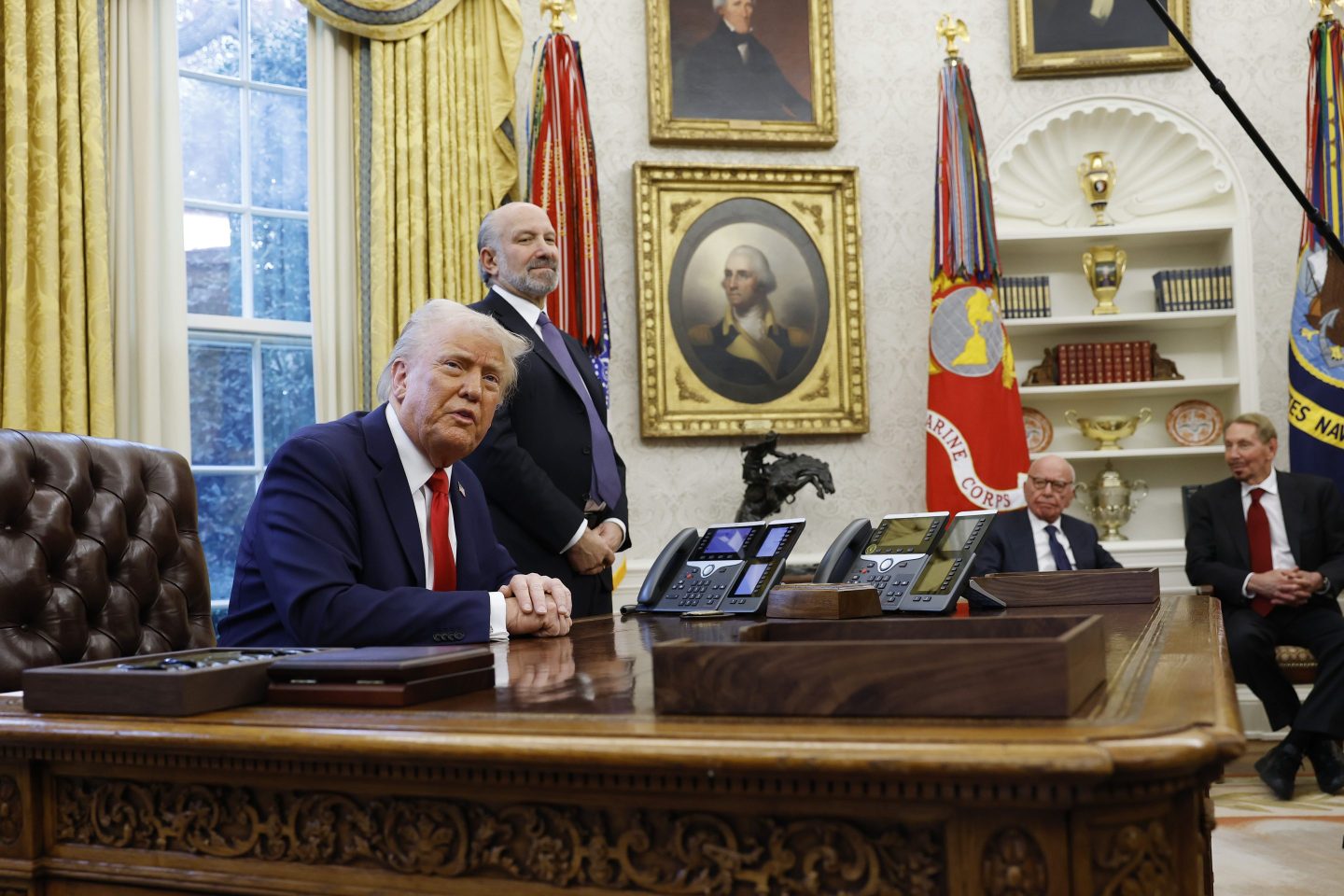 President Donald Trump signs executive orders regarding tariffs in the Oval Office.