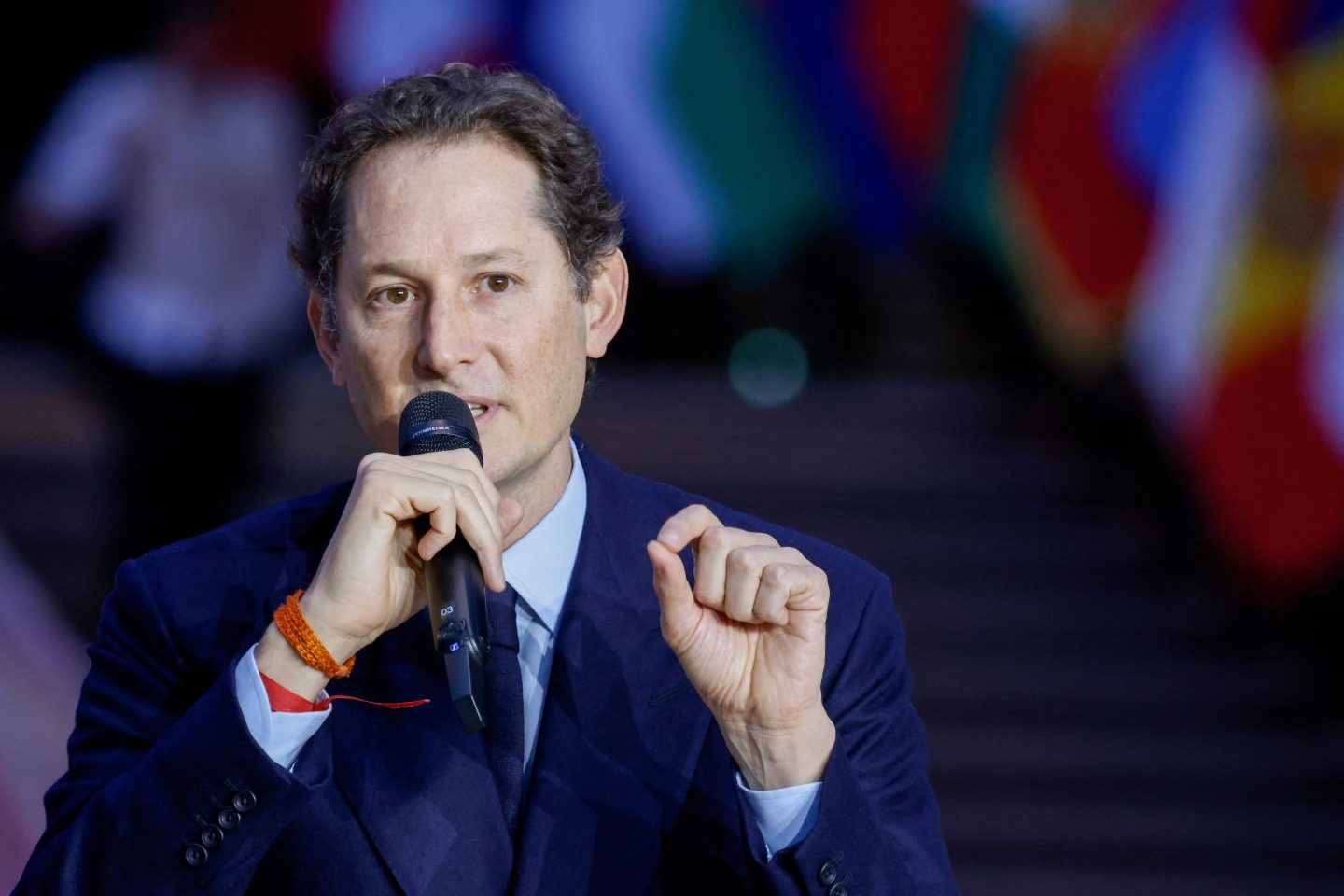 Stellantis chairman John Elkann speaks into a microphone