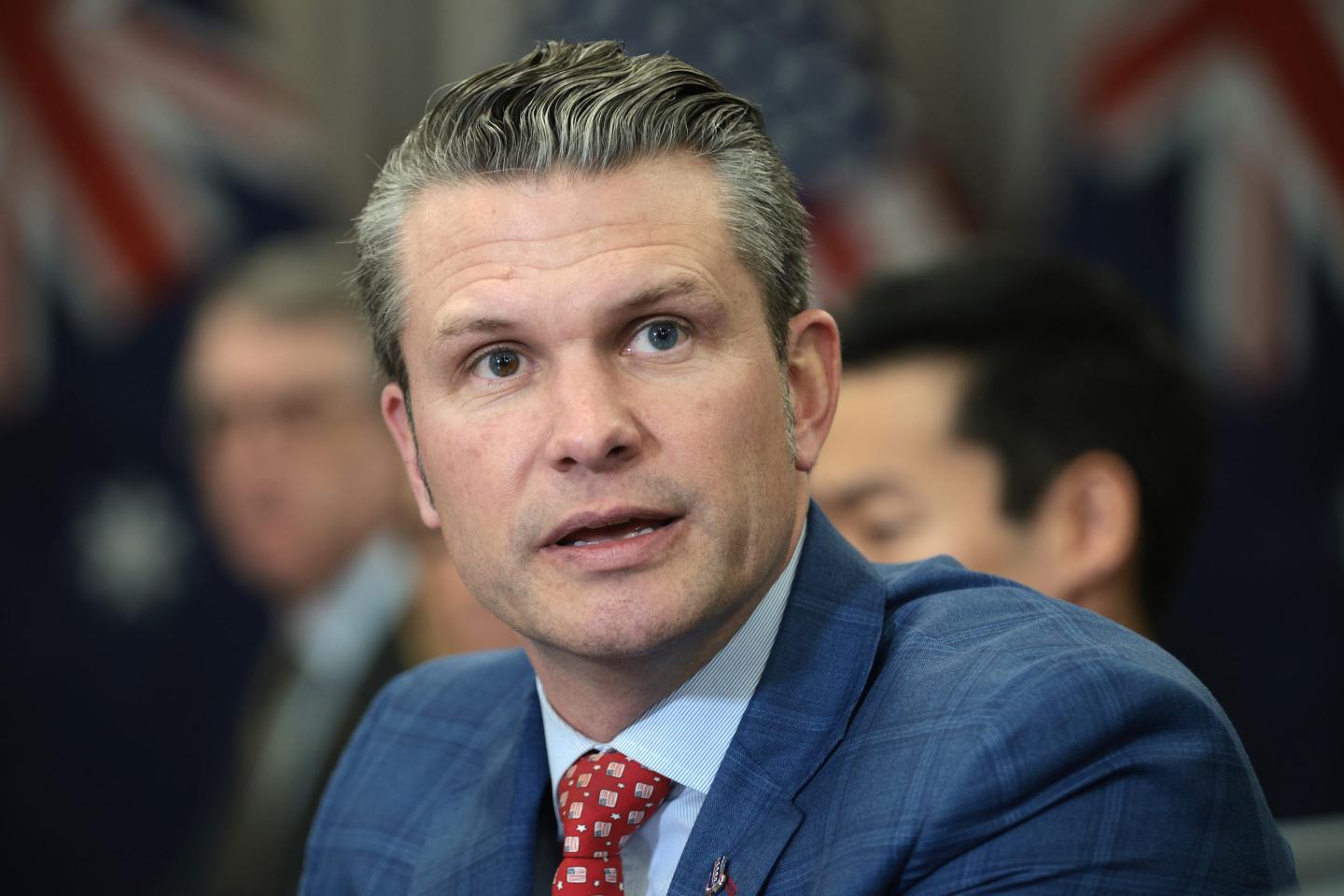 Pete Hegseth speaks while sitting at a table