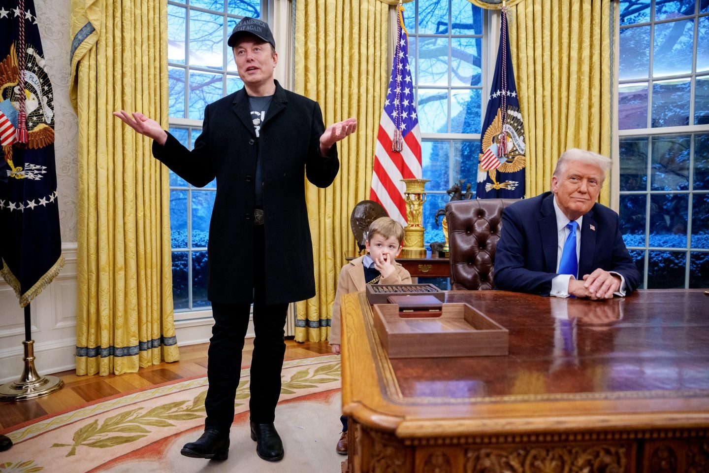 Tesla and SpaceX CEO Elon Musk, accompanied by U.S. President Donald Trump (R), and his son X Musk, speaks during an executive order signing in the Oval Office at the White House on February 11