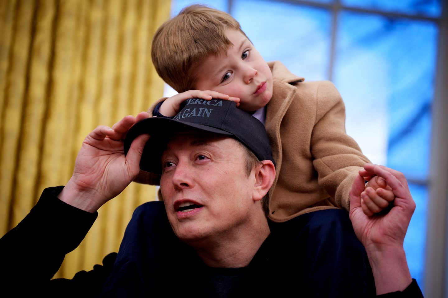 Elon Musk with his young son sitting on his shoulders