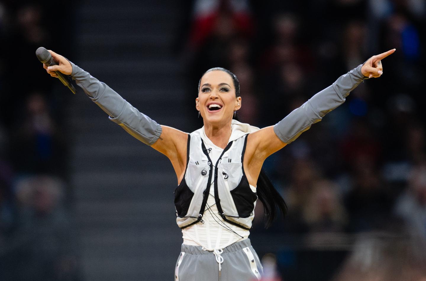 Katy Perry holds out her arms after a performance