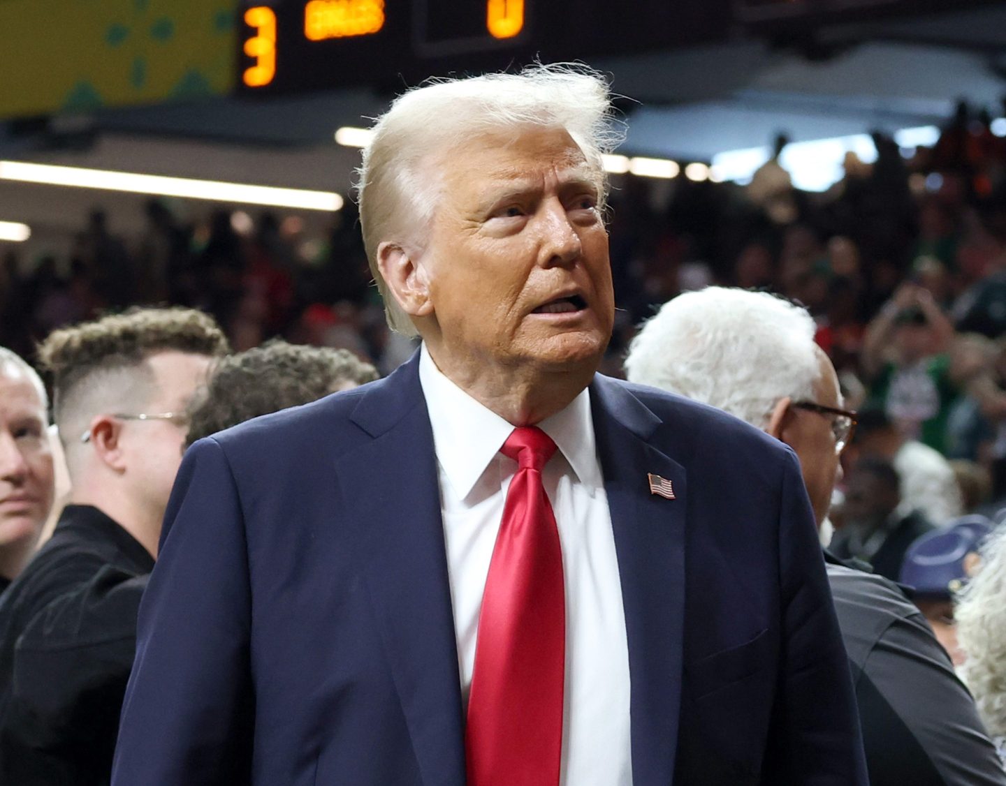 Donald Trump grimaces and looks to his left while on the field pregame at the Super Bowl.