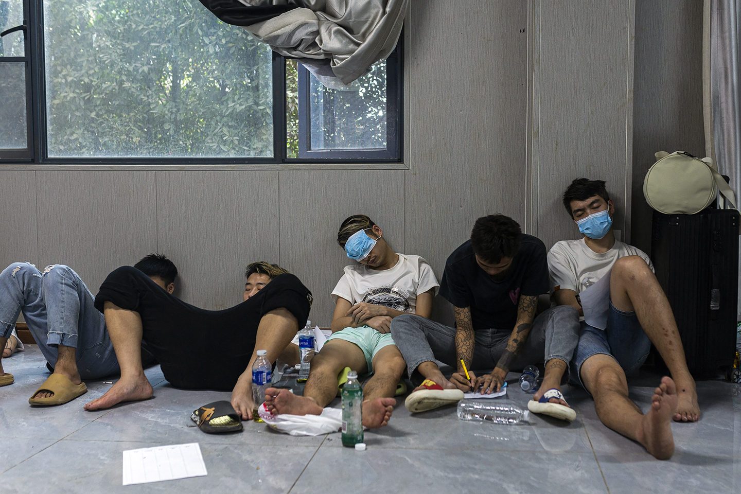 Alleged scam centre workers and victims rest during a crackdown operation by the Karen Border Guard Force (BGF) on illicit activity in Shwe Kokko in Myanmar's eastern Myawaddy township on Feb. 14, 2025.