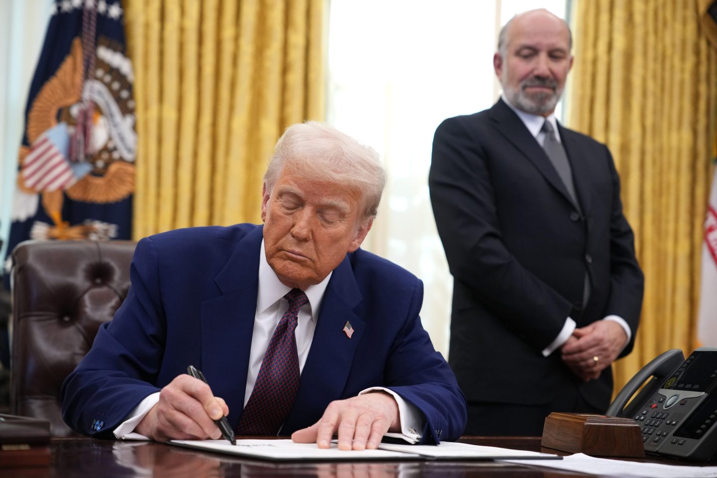 U.S. President Donald Trump, joined by Secretary of Commerce Howard Lutnick, signs an executive order on reciprocal tariffs in the Oval Office at the White House on February 13