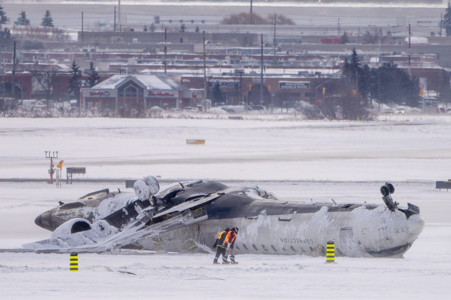 A Delta plane lays upside-down in the snow after its crash landing in Toronto