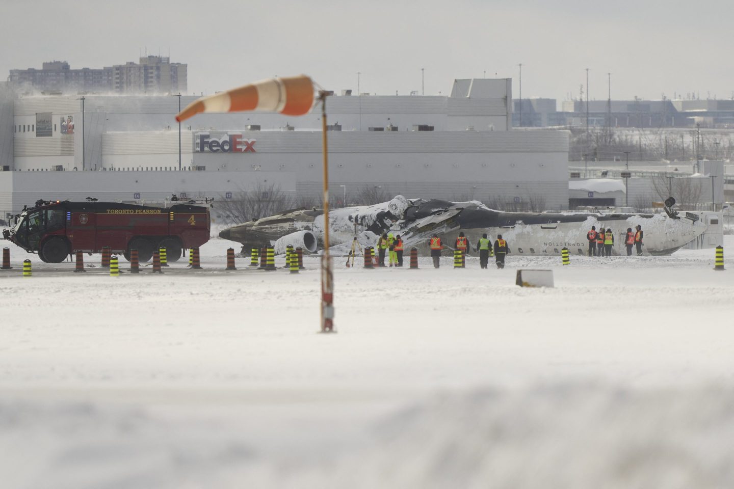Investigators examine the wreckage of a Delta Air Lines plane on Feb. 18, 2025, a day after it crash-landed at Toronto Pearson International Airport.