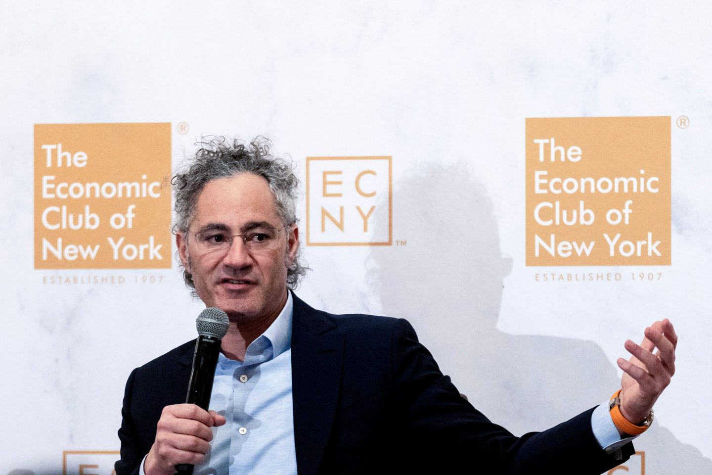 Alex Karp puts out his left hand as he talks at the Economic Club of New York.