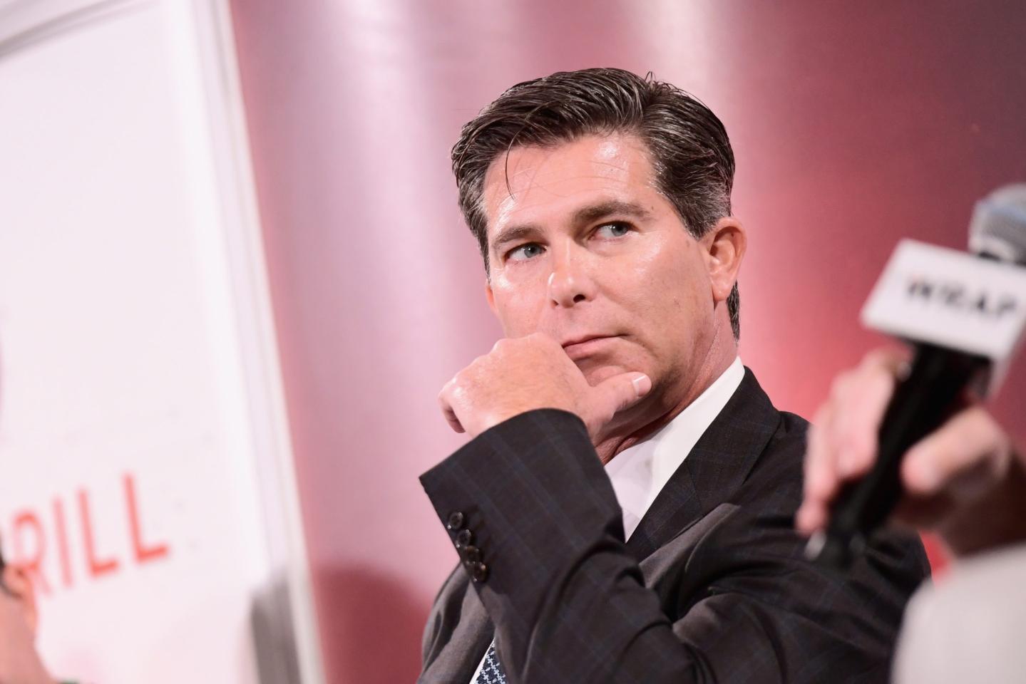 Ross Gerber puts his hand to his face while on a panel