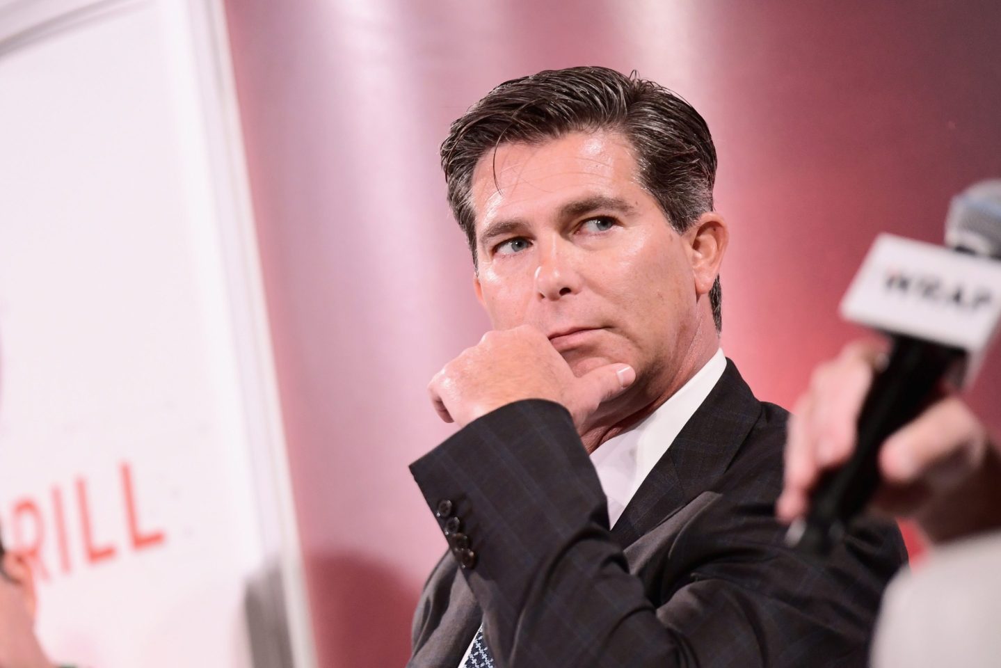 Ross Gerber puts his hand to his face while on a panel