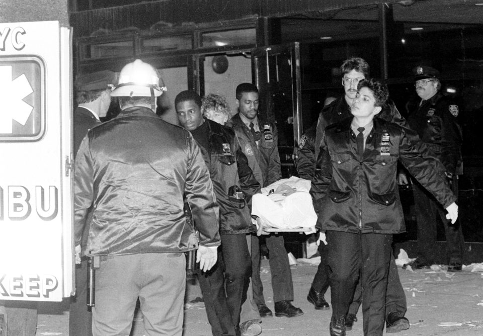 Emergency officials carry a gurney into an ambulance.