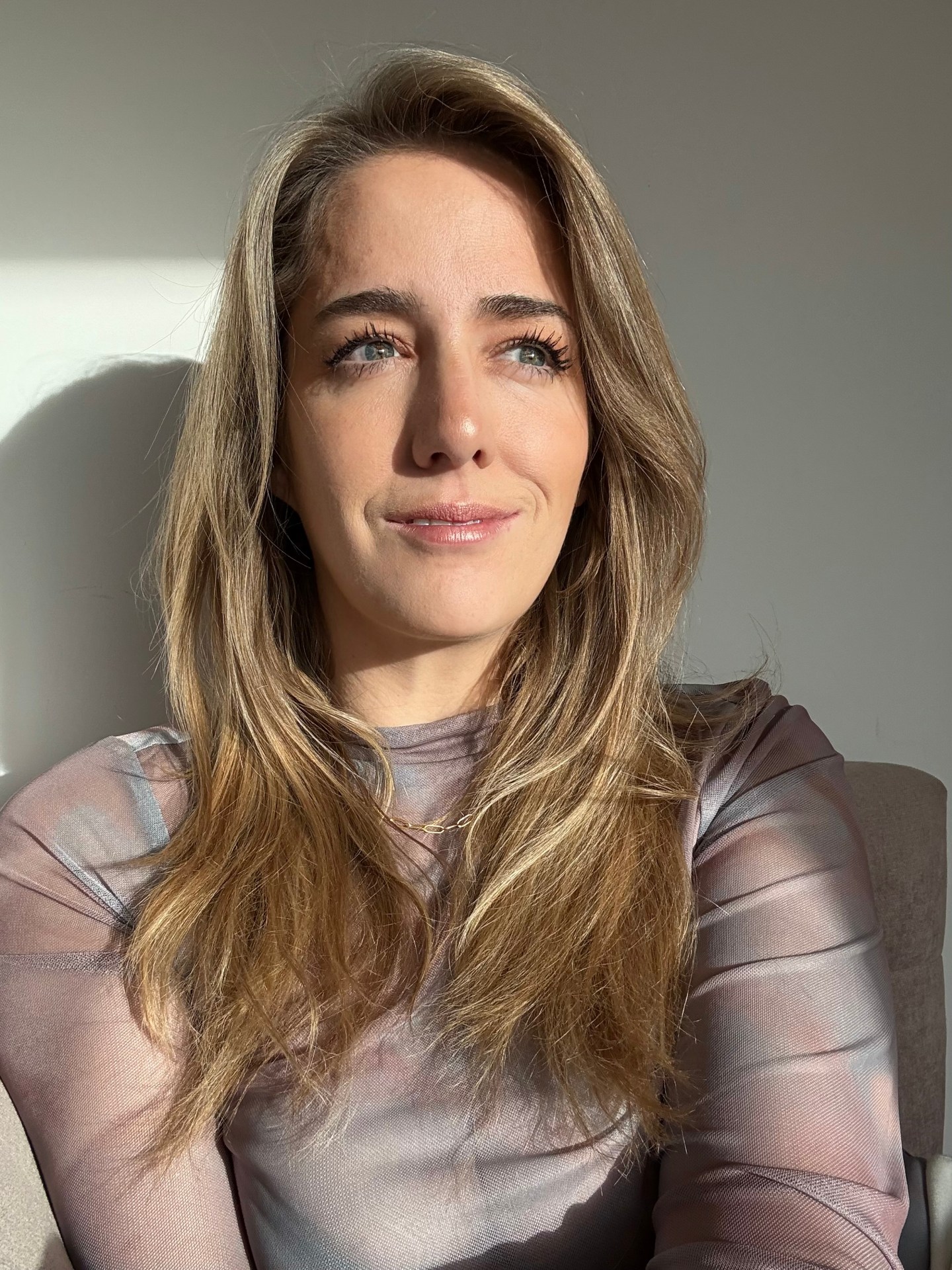 Headshot of Kelly Stonelake smiling and wearing a silver top.