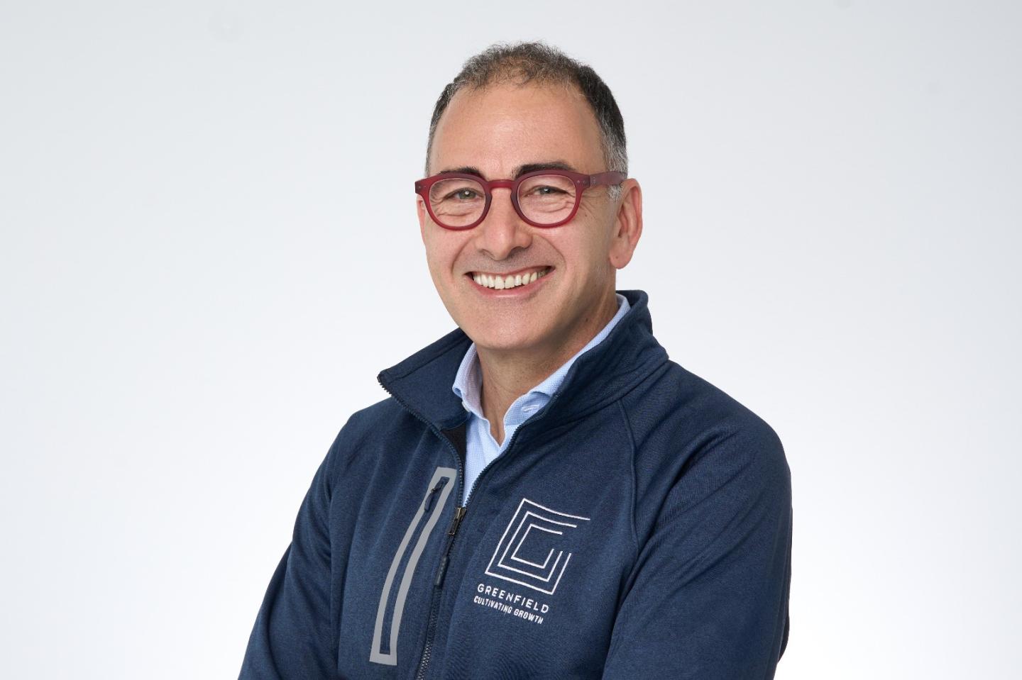 middle-aged man in red glasses and business casual clothing smiling for a photo portrait