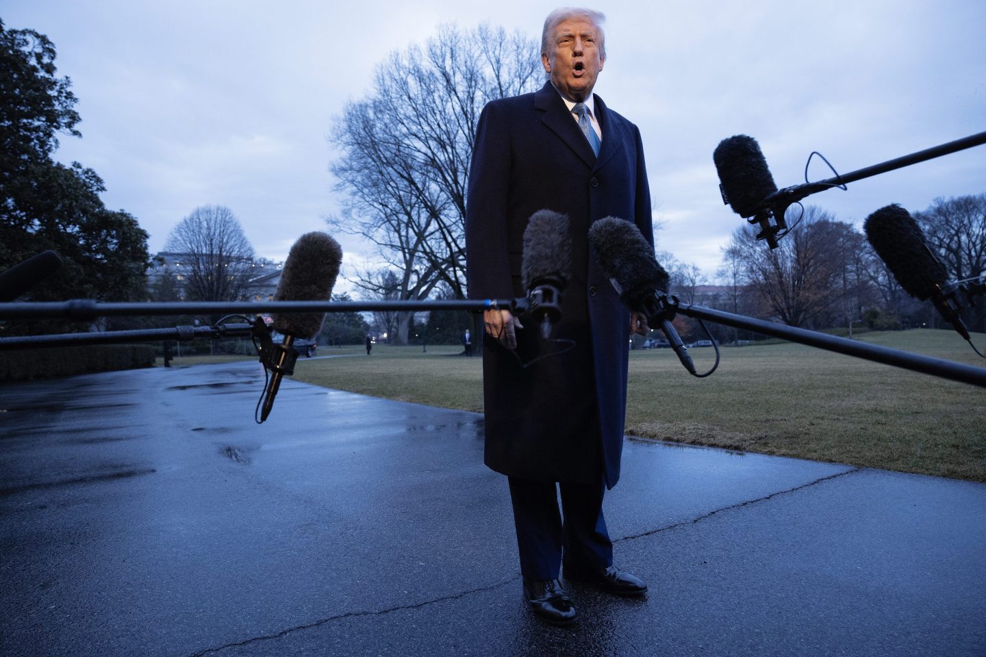 Donald Trump stands before microphones