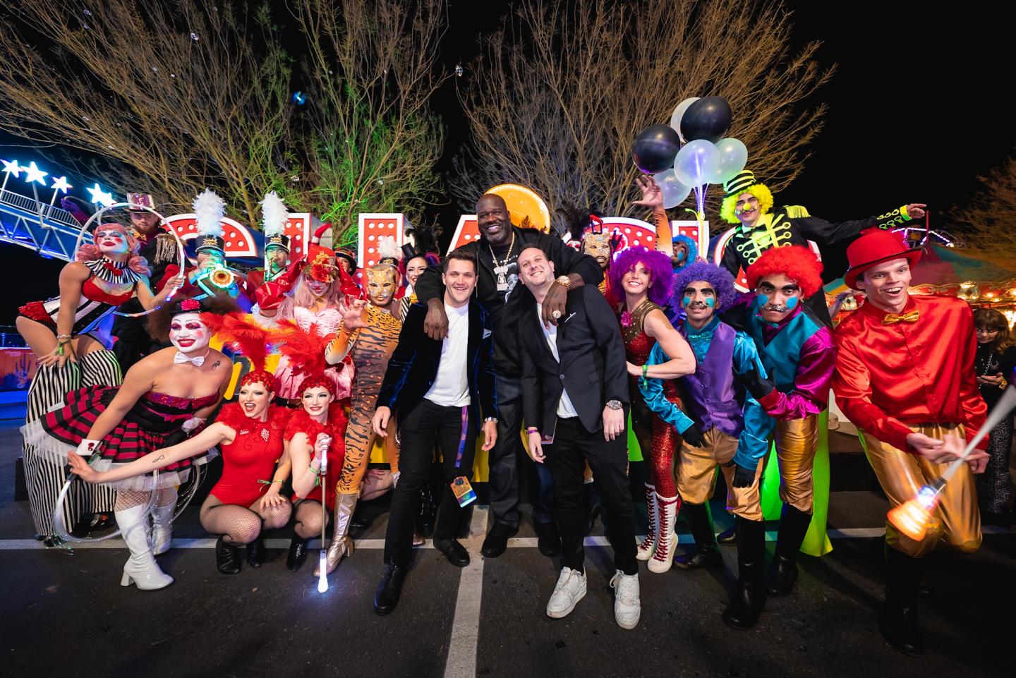 Shaq posing with carnival characters and Medium Rare co-CEOs