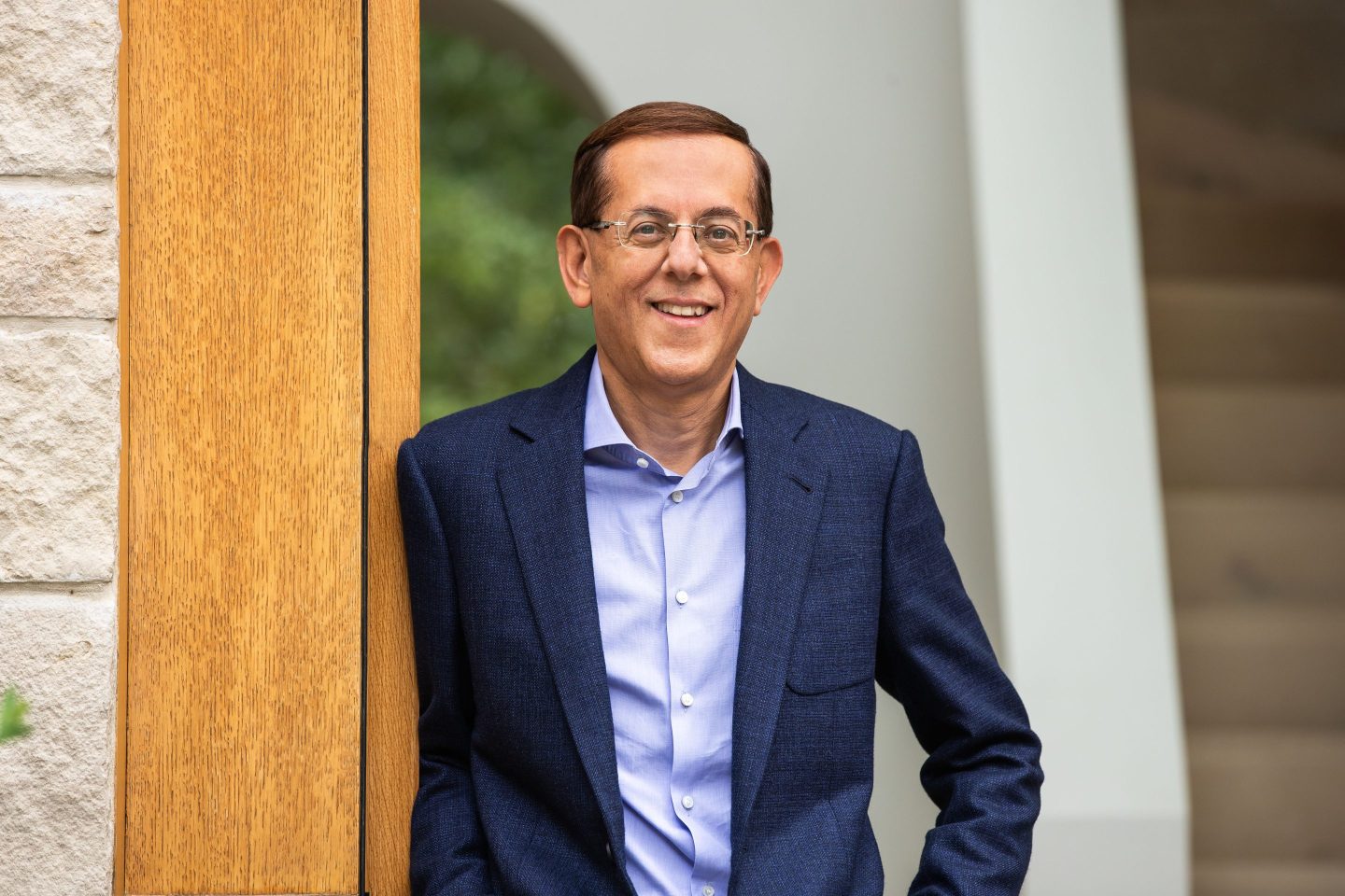 man in wire-rim glasses and business attire poses for a photo portrait