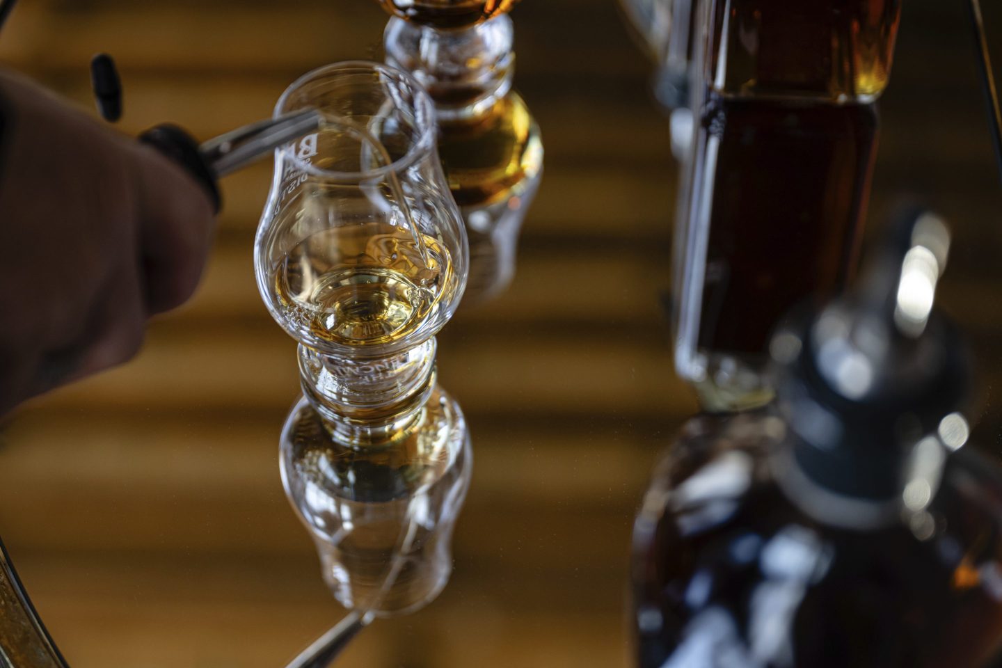 An employee pours a glass of The Bard's product in what will be a new production area at The Bard Distillery in Graham, Ky., on March 9, 2025.