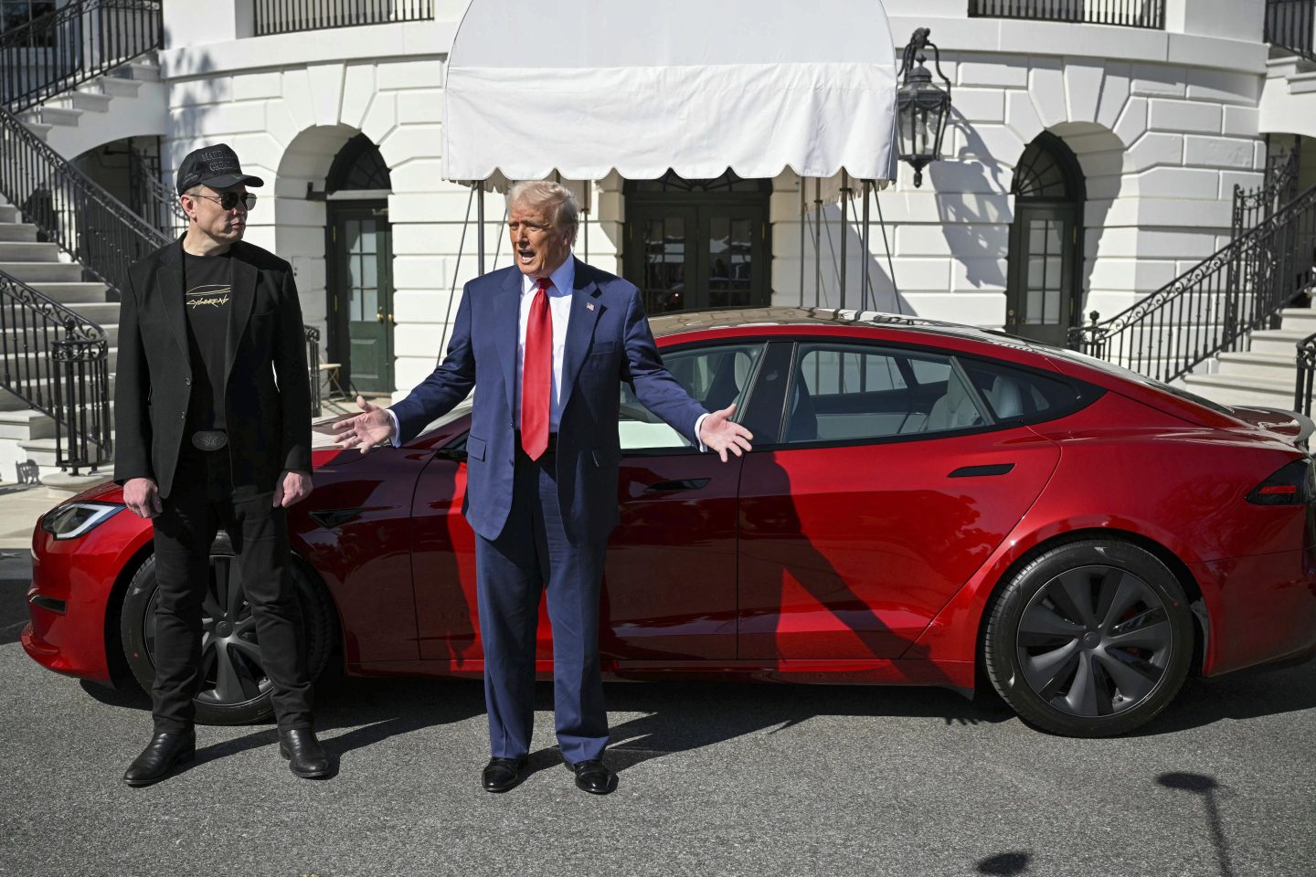 President Donald Trump and Tesla CEO Elon Musk speak to reporters near a red Model S Tesla vehicle on the South Lawn of the White House on March 11, 2025, in Washington.
