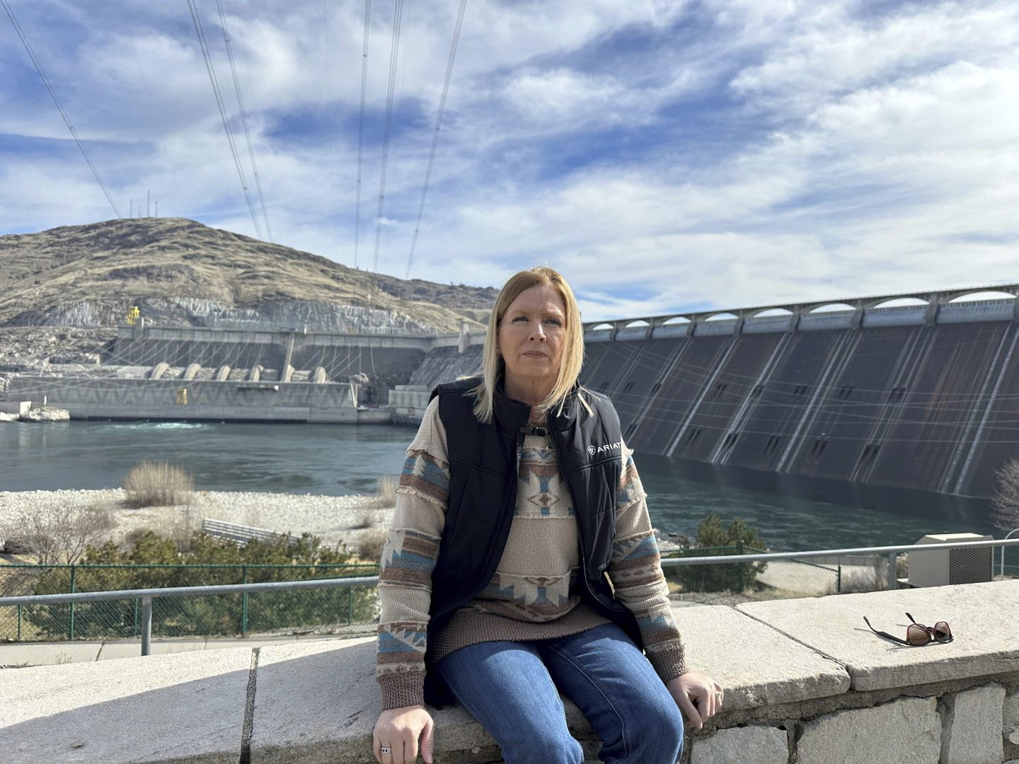 Former Grand Coulee Dam worker, Stephanie Duclos, sits in front of the Grand Coulee Dam on Feb. 28.