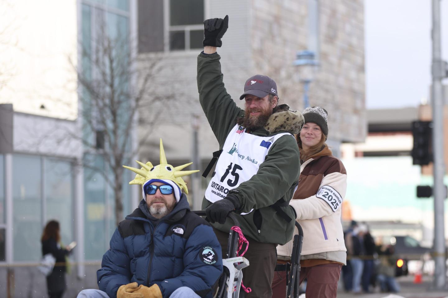 Jessie Holmes pumps his fist in the air after beginning the Iditarod