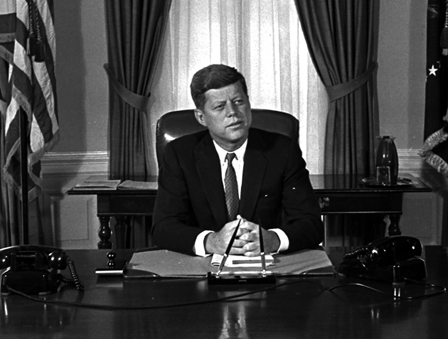 Newly-elected President Kennedy posed for first pictures at his White House desk, Jan. 21, 1961, before plunging into a busy round of conferences.