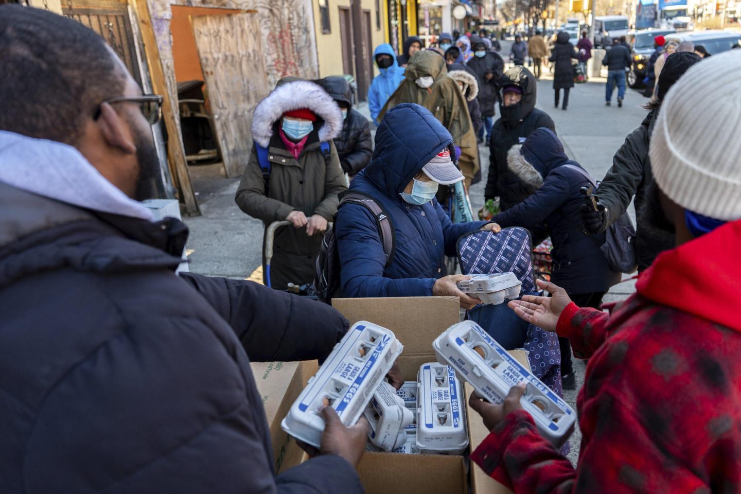 Abou Sow hands out cartons of eggs to people waiting in line to receive free eggs from FarmerJawn Agriculture, Friday, March 21, 2025, in the Harlem neighborhood of New York.