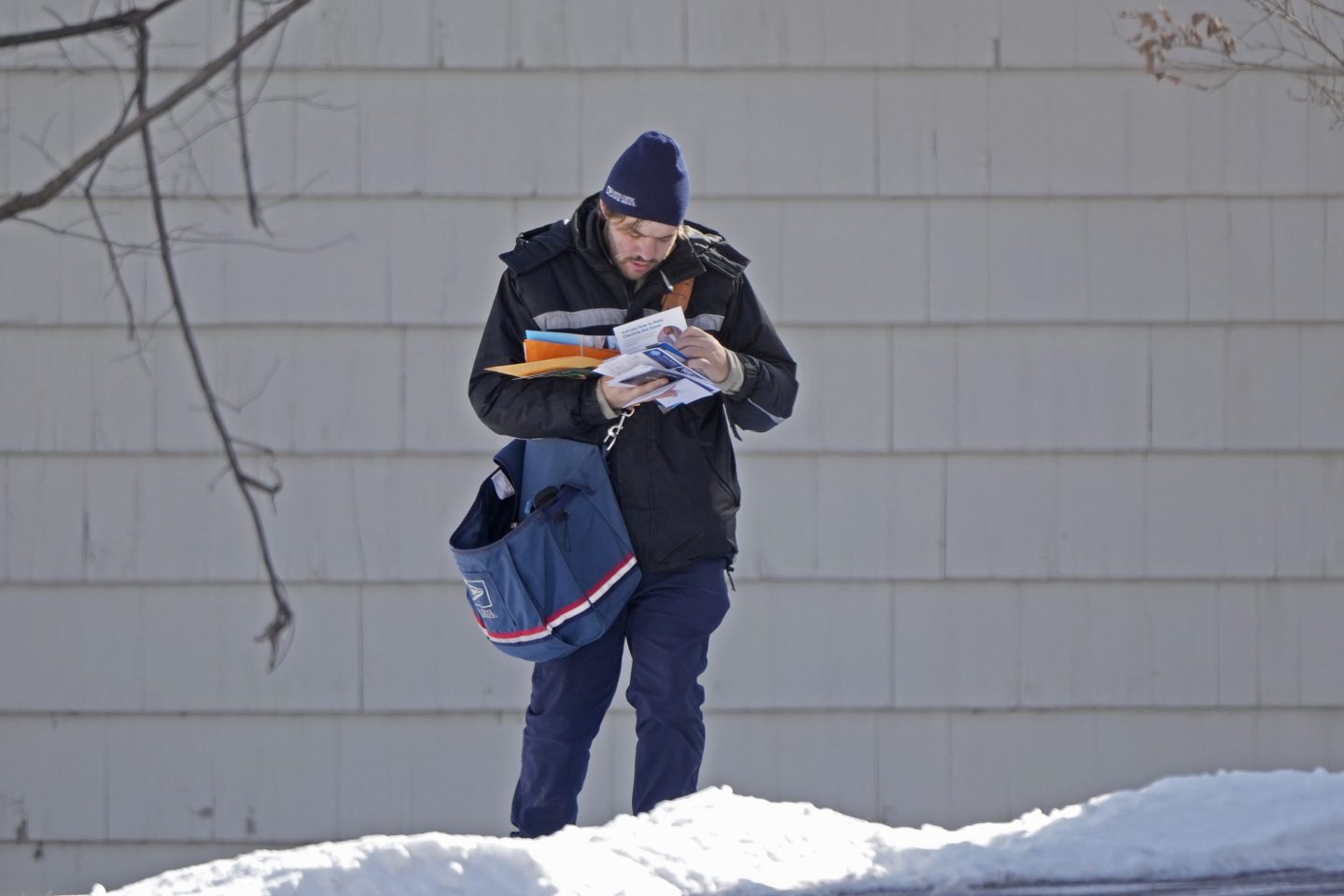 A U.S. Postal Service letter carrier delivers mail, Friday, Feb. 21, 2025, in Overland Park, Kan.