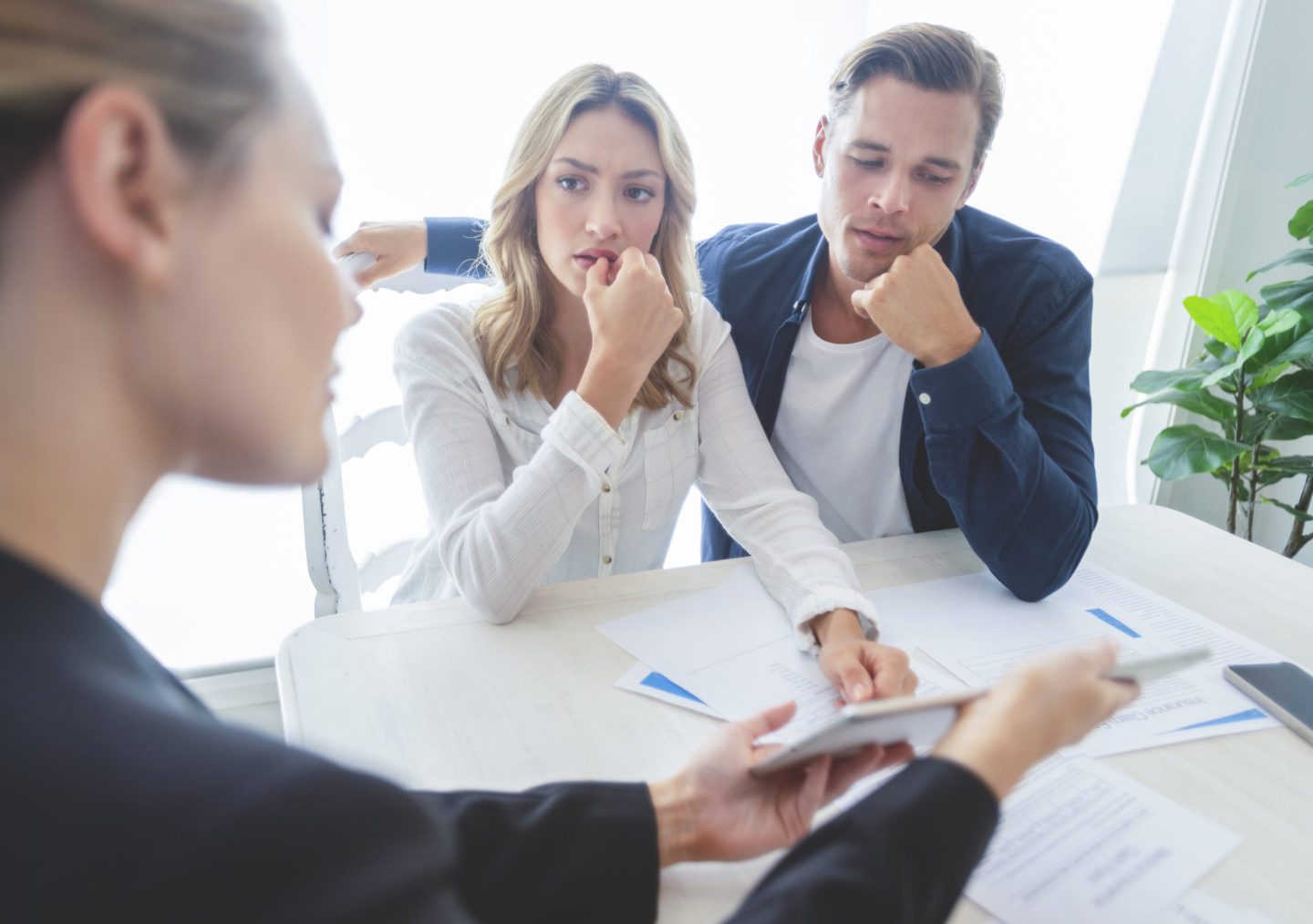 Real estate agent with two buyers looking through documents
