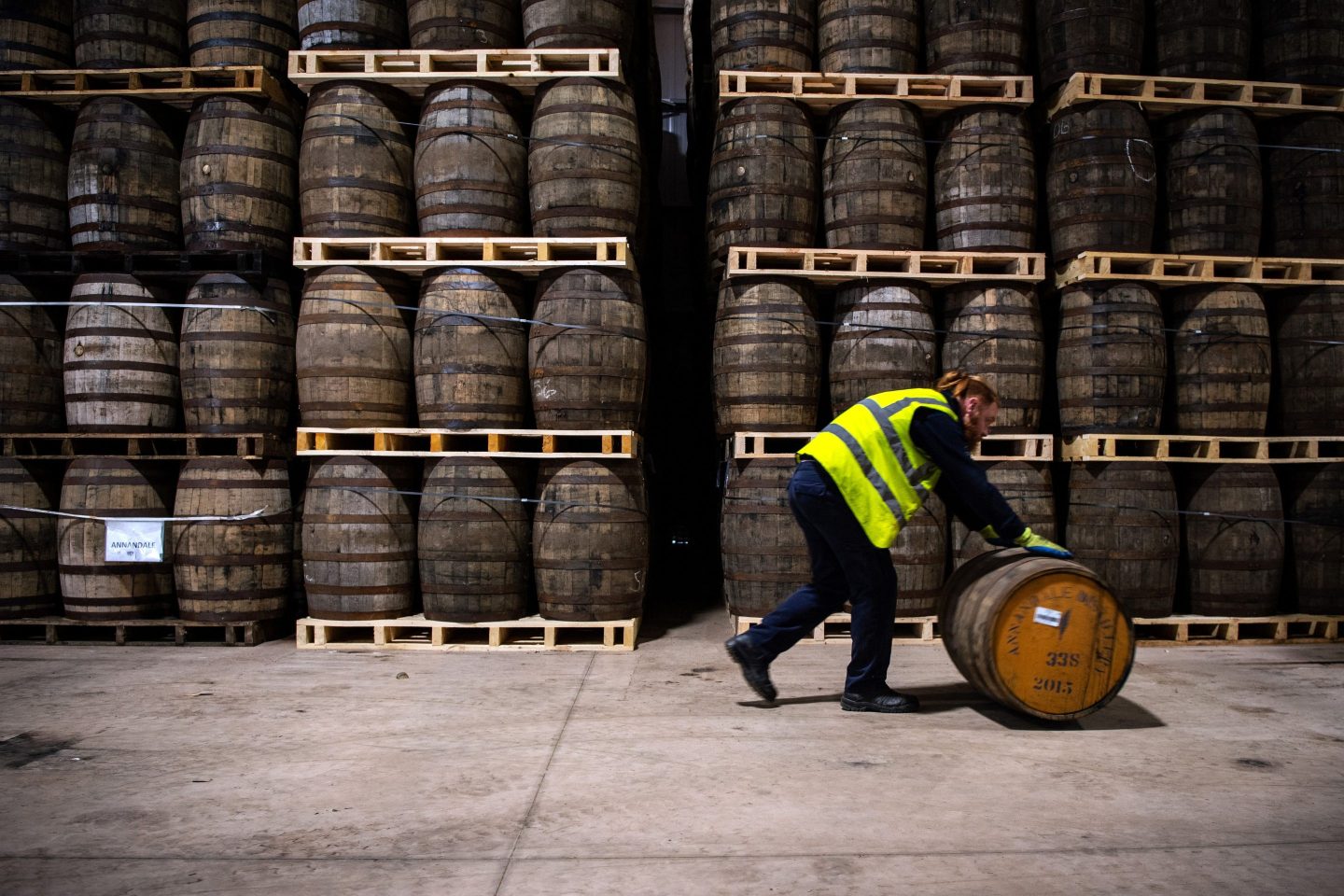 man rolling whiskey barrel