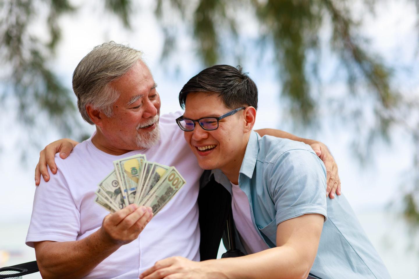 Father gives cash to adult son.