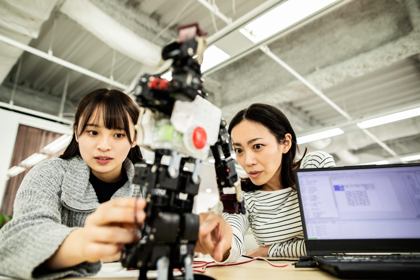A female researcher at a start-up company examining a robot prototype