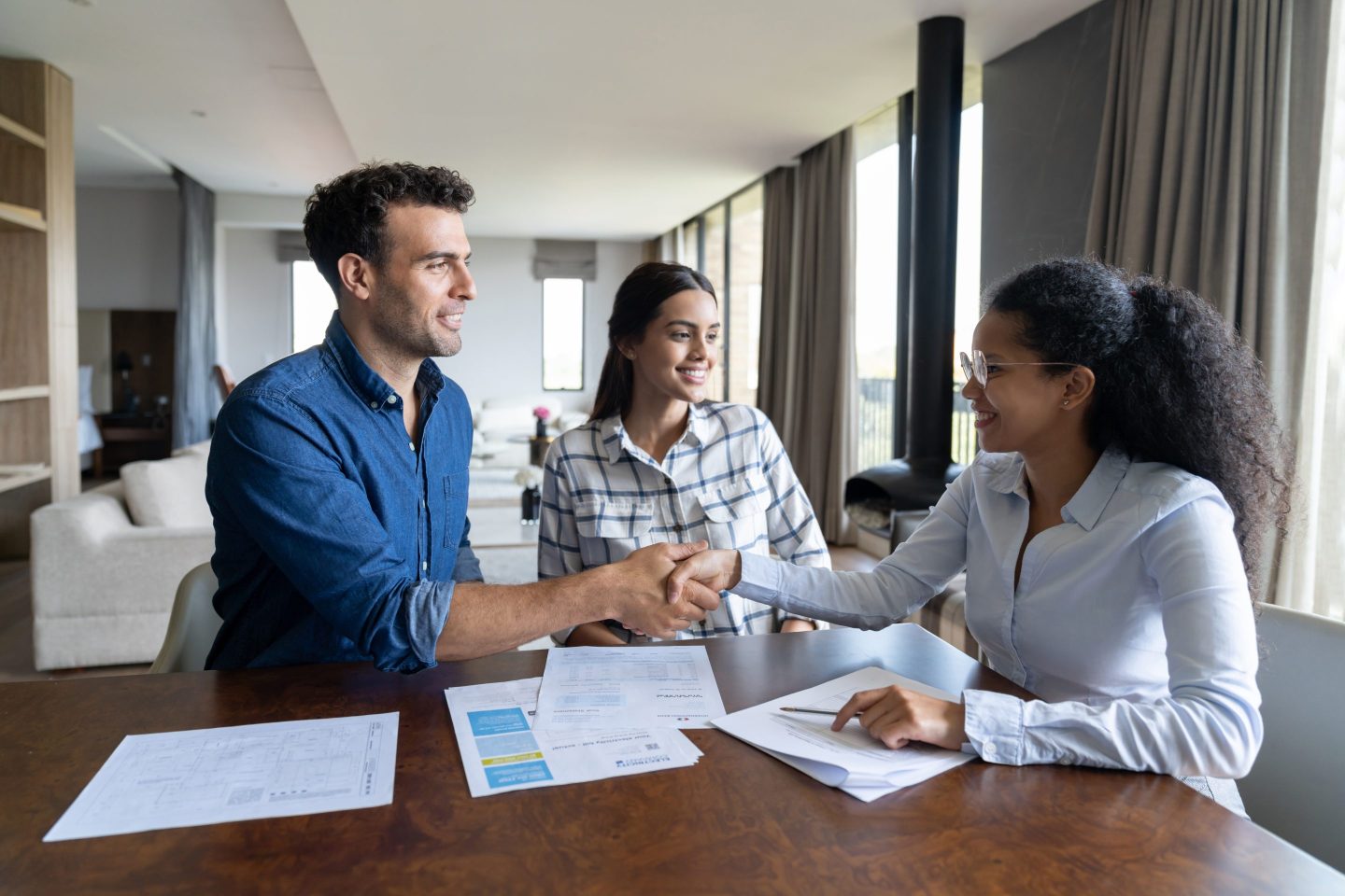 couple shaking hands with realtor