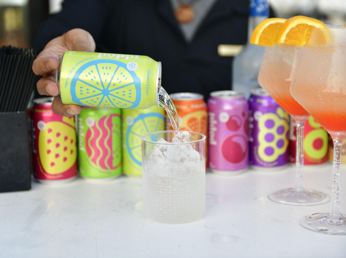 man pouring Poppi soda into glass