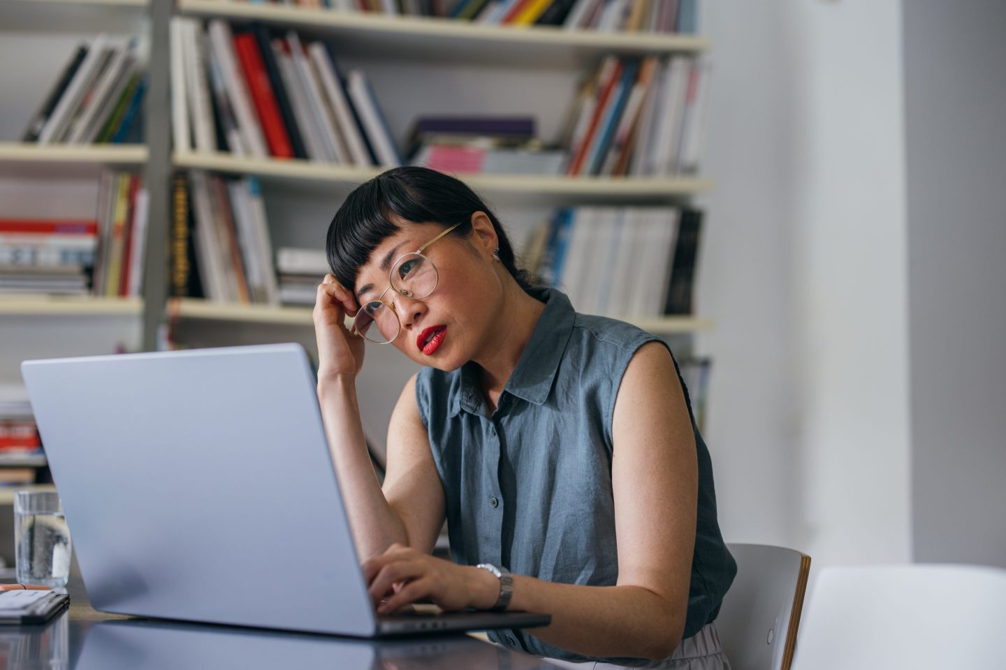 a frustrated business woman with glass on at her computer