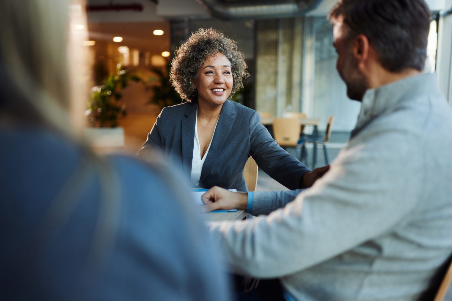 woman sitting at a table talking to coworker