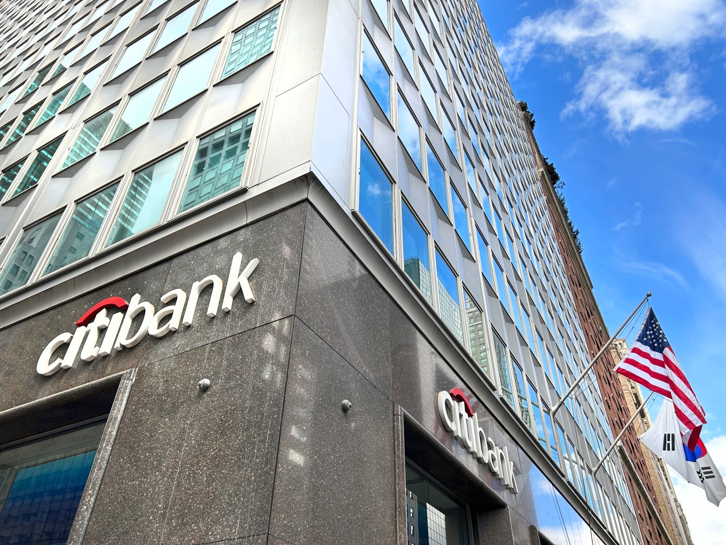 the outside of a Citibank at the bottom of a high rise building