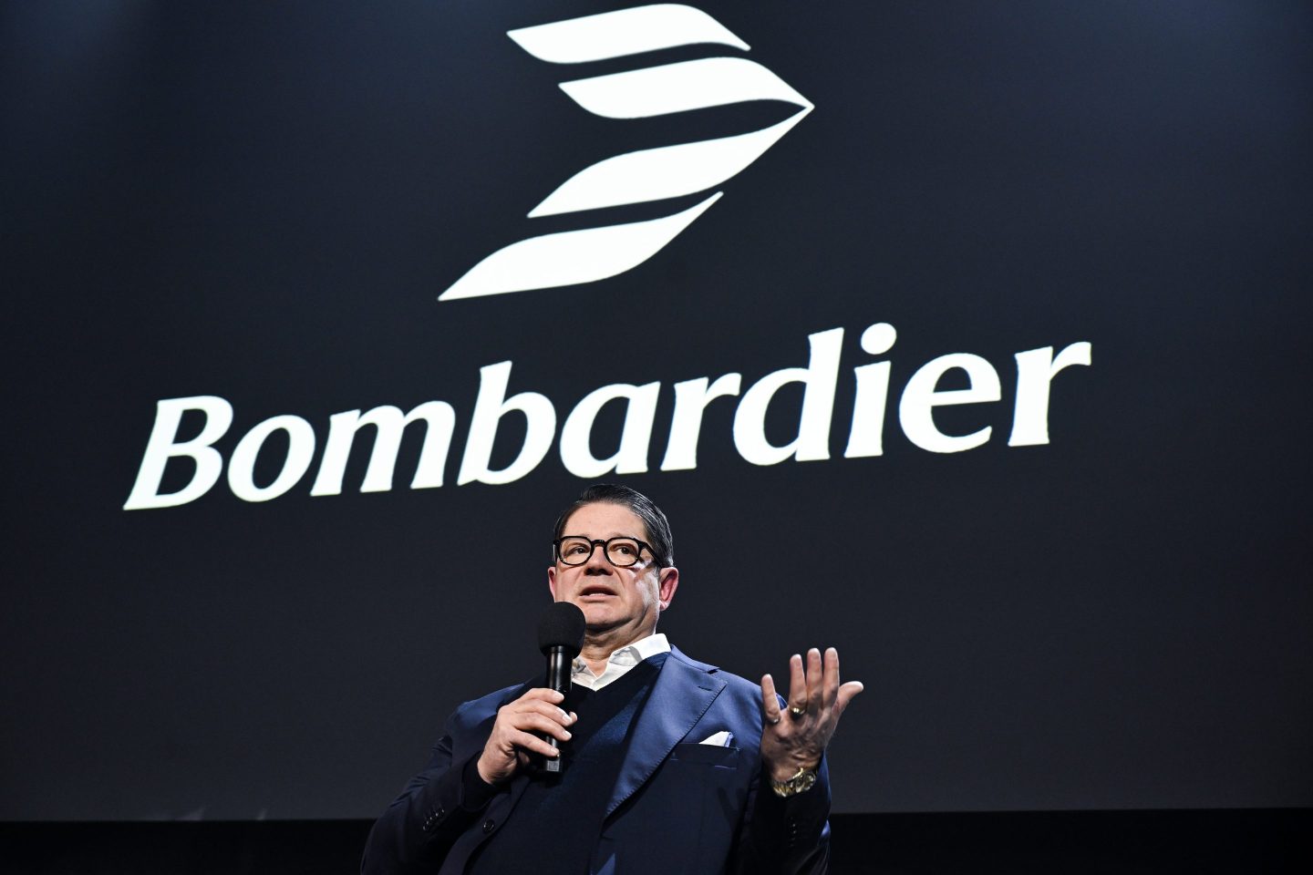 Bombardier's CEO stands in front of his company's logo