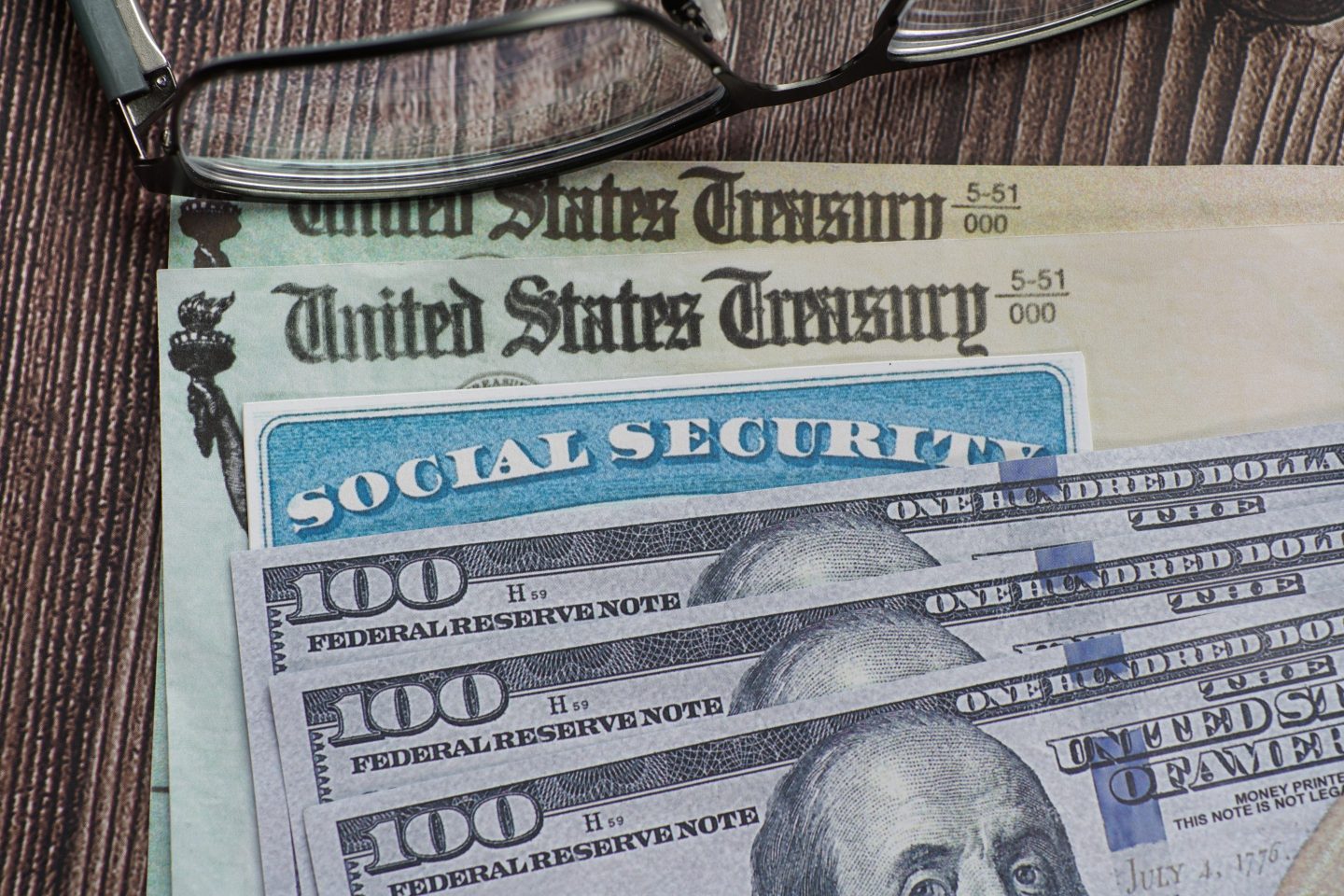 Fake Social security card on prop U.S. currency and Treasury Department checks.