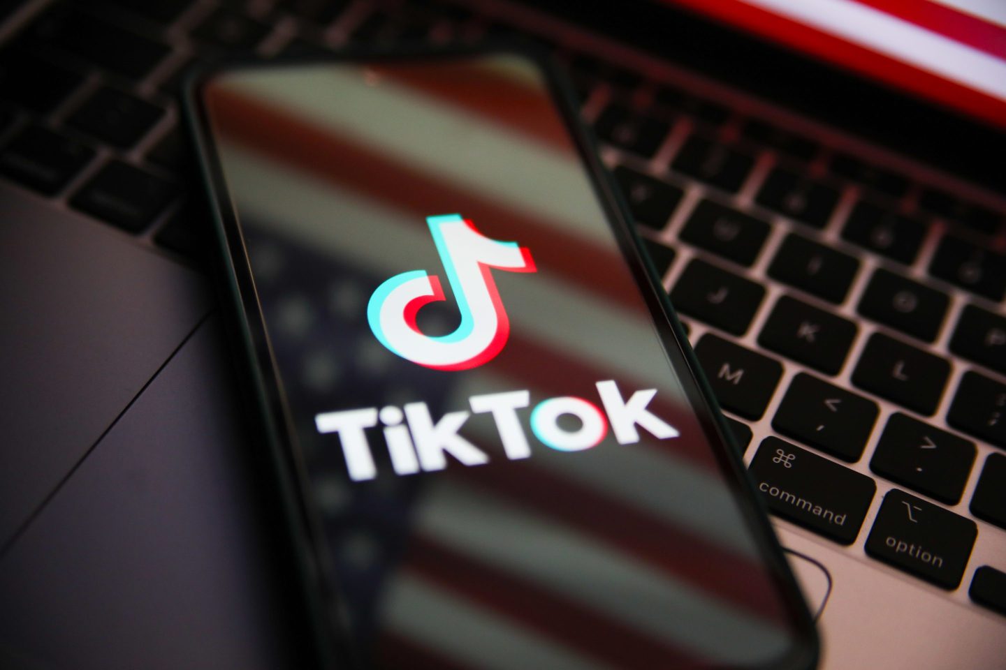 Closeup of TikTok on a phone screen set atop a laptop keyboard