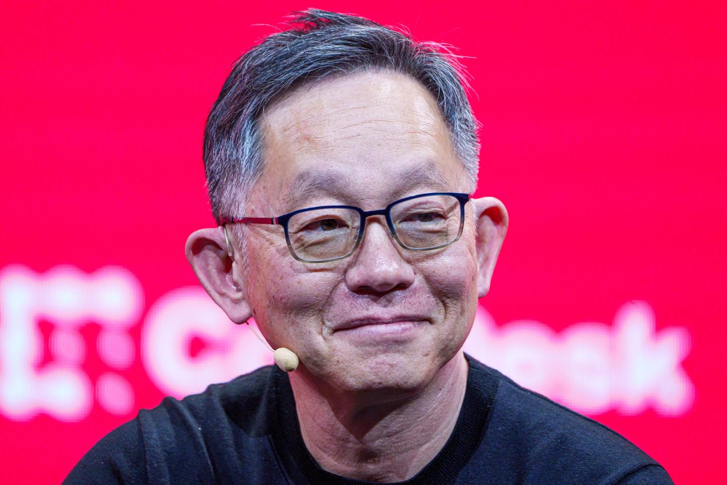 Evan Cheng smiles on stage at a crypto conference.