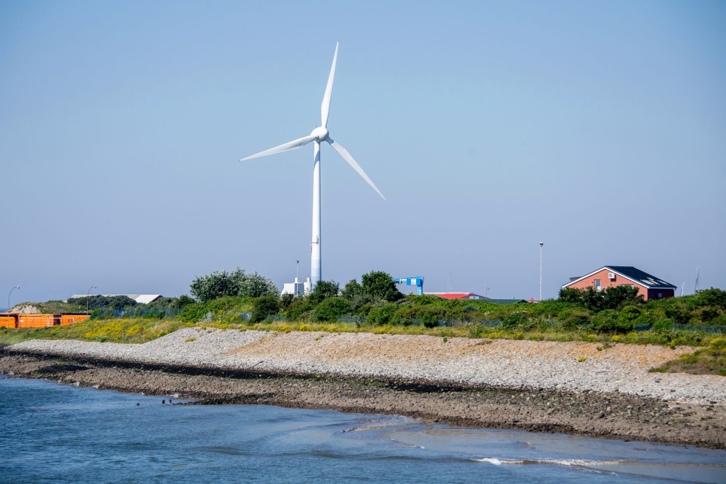 A wind turbine stands in the harbor of the North Sea island.
